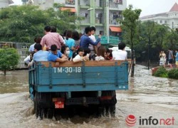 Giữa Hà Nội: Máy xúc đưa người dân qua chỗ ngập nước