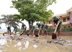 Bộ đội giúp dân dọn bùn sau lũ