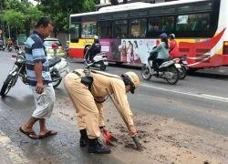 CSGT Hà Nội dừng xe thu dọn bùn đất vương vãi trên đường