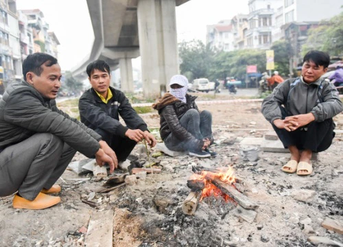 Người dân Hà Nội đốt củi sưởi ấm trên đường trong ngày mưa rét