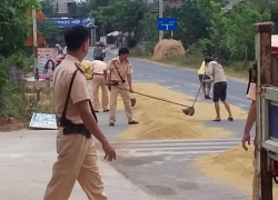 CSGT khom lưng cào lúa giúp bà con đang chạy cơn giông