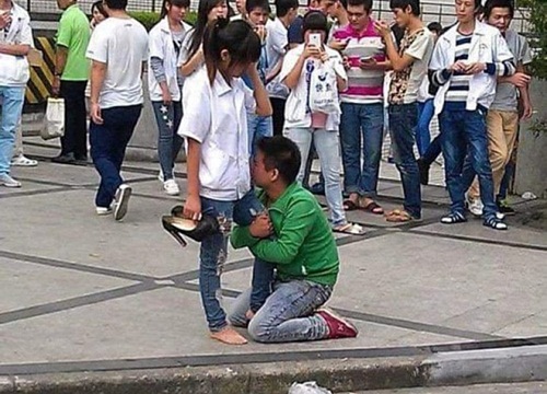 Chàng trai quỳ gối, ôm chân cô gái không chịu rời, bó hoa bị vứt sang một bên