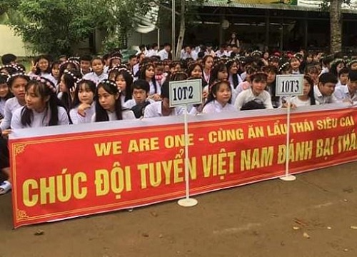 Học sinh mang băng rôn cổ vũ đội tuyển Việt Nam đến lễ khai giảng