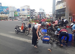 Hai người nước ngoài giúp xe máy chở cá bị đổ giữa đường