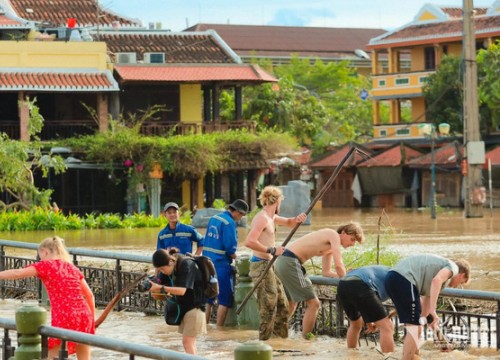 Du khách nước ngoài dọn rác sau bão ở Hội An