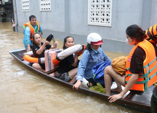 Công an lội nước đẩy thuyền giúp người dân thoát khỏi vùng ngập lụt nguy hiểm