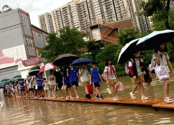 Hà Nội ngập sâu, trường học kê bàn thành 'cầu' cho học sinh ra về