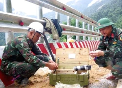 Bộ đội công binh nhồi thuốc nổ phá đá thông đèo Khánh Lê