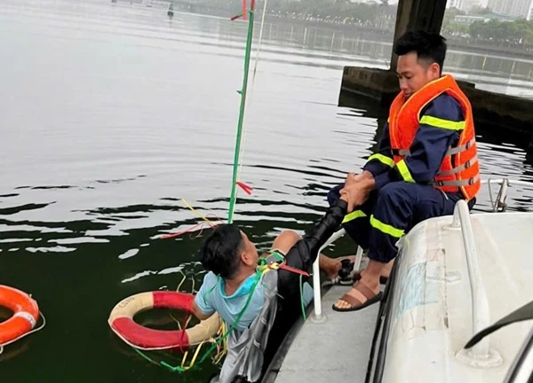 Hình ảnh người đàn ông đu mình dưới sông chờ ứng cứu sau khi nhảy cầu tự tử