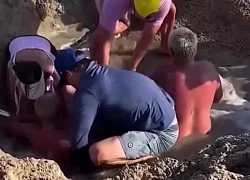 Trẻ chơi trong hố cát ngập nước suýt bị chôn vùi, được người đi biển cứu