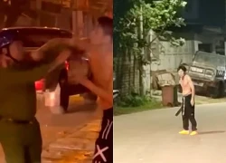 Thanh niên cởi trần cầm 2 con dao lao ra đường chặn xe, đấm công an
